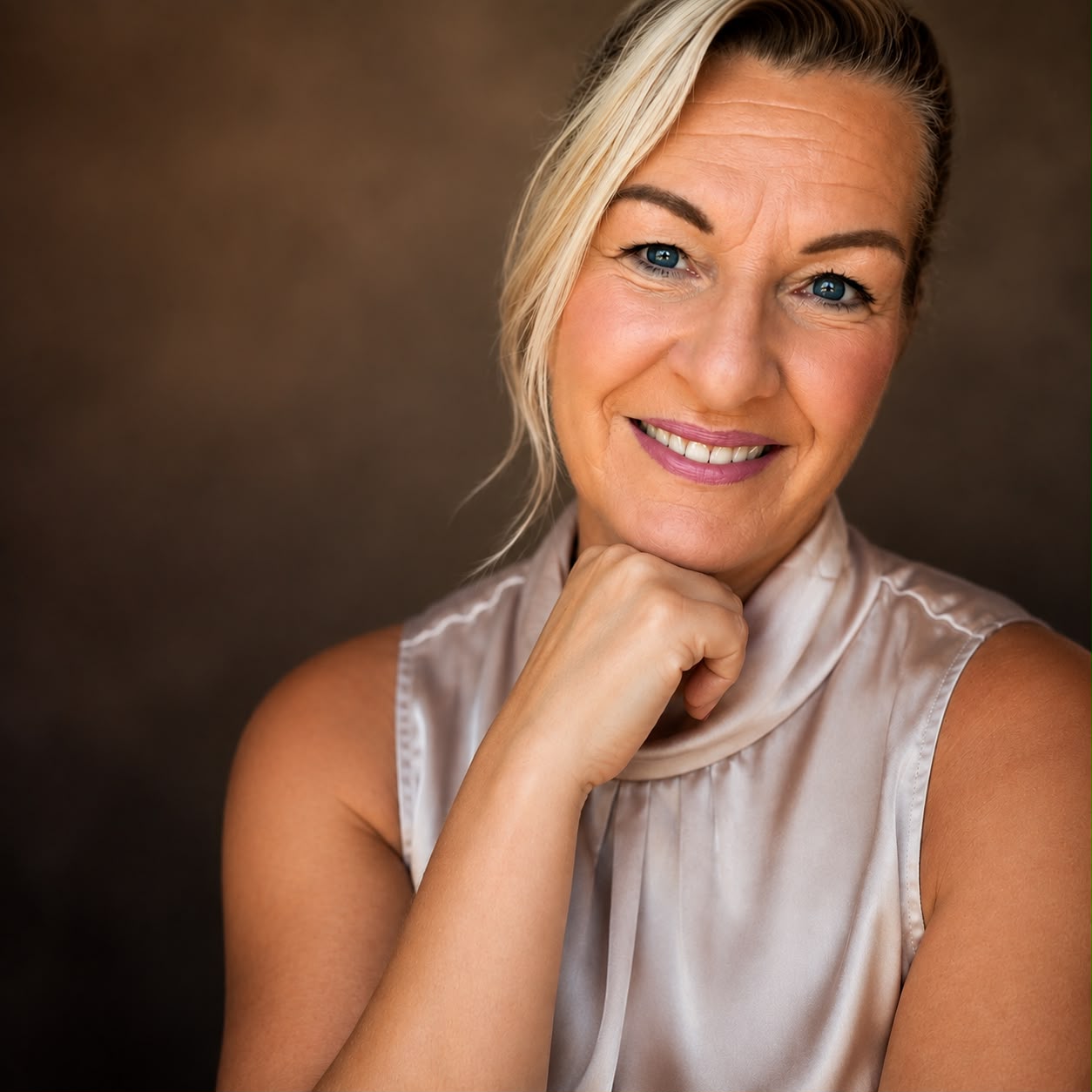 Mirjam Bikker smiling with her chin resting on her hand in a studio portrait